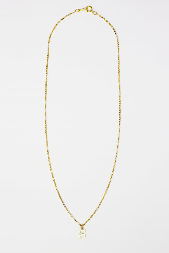 Gold necklace on a light gray background